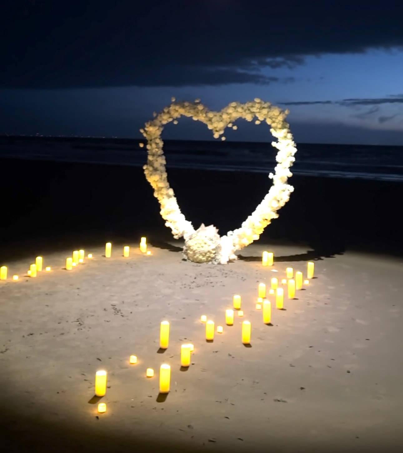 Het verlichte Rozenhart op het strand met kaarsenpad